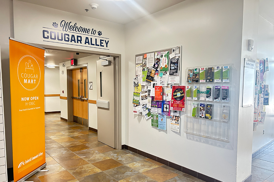 bulletin board next to doorway with cougar alley on sign above door