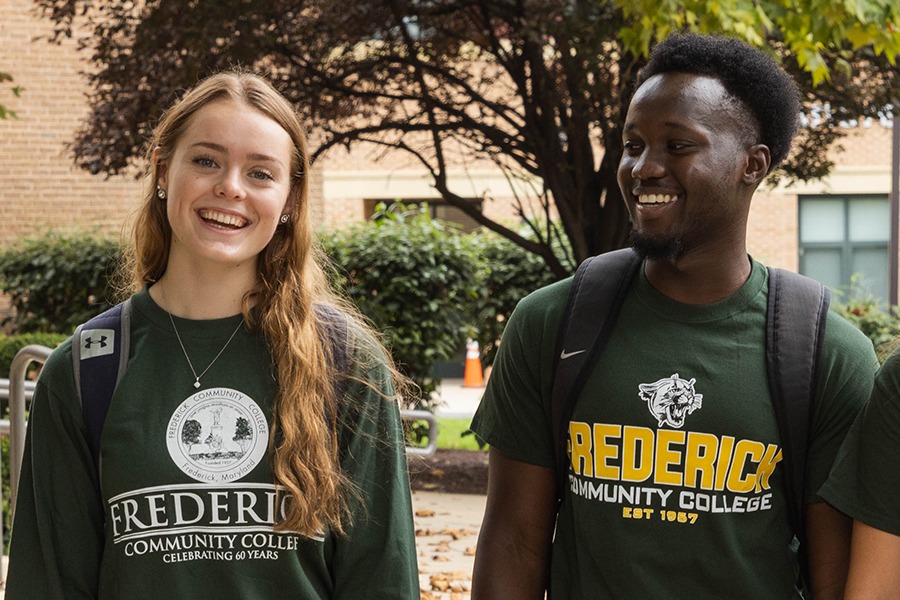 smiling students wearing green fcc shirts