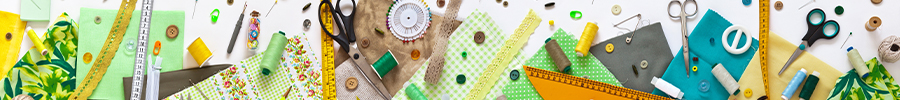 A colorful flat lay of sewing supplies including fabric, thread, scissors, and buttons.